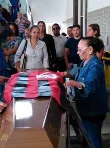 Josefa, a viúva, estende a bandeira do Flamengo sobre o caixão. Foto: Marcelo Auler